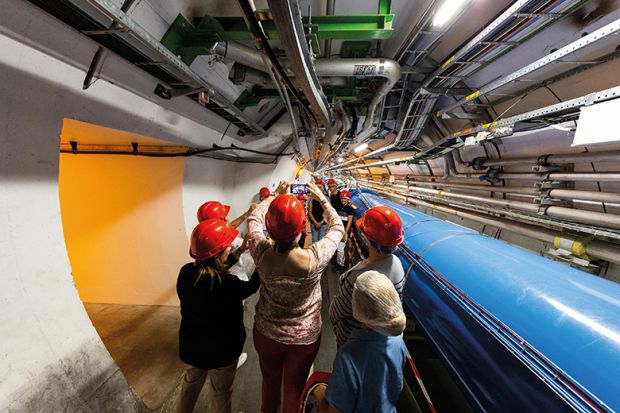 People in hard hats in tunnel at CERN lab