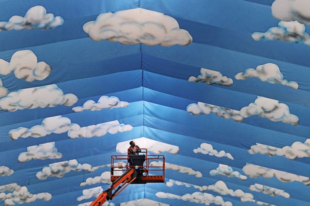 Cherrypicker against cloud mural
