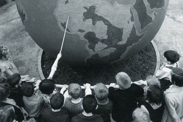 Children viewing globe during geography lesson