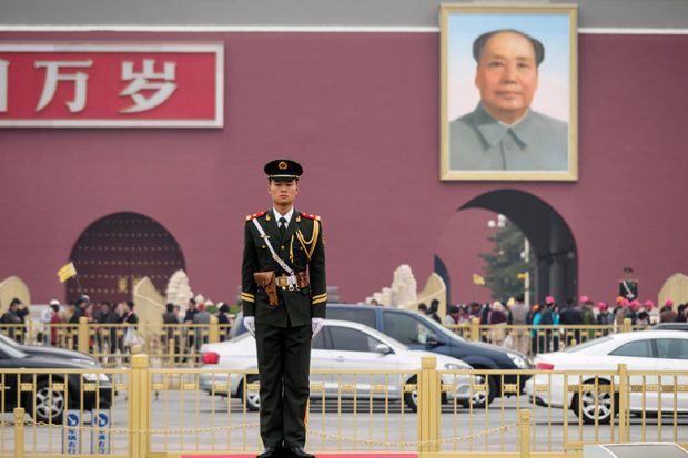 Chinese soldier with poster of Chairman Mao