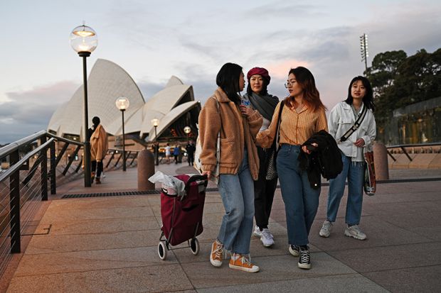International students from China walk along the waterfront by the Sydney Opera House, after lockdown measures put in place to prevent the spread of the coronavirus outbreak were eased, June 2020. Will China pull the plug on Australian enrolments?