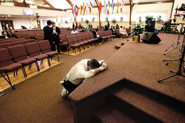 man prays in church