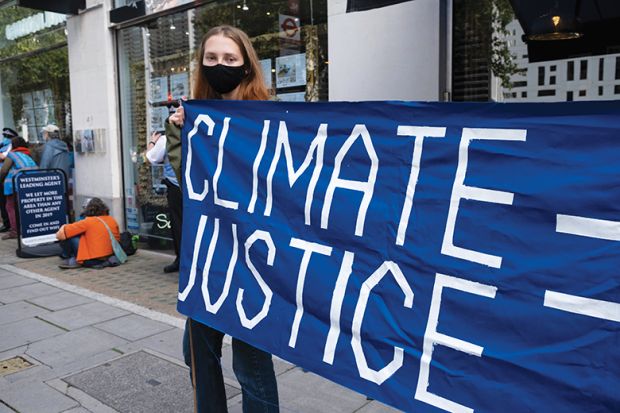 Woman holding climate justice protest banner