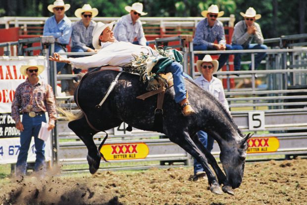 Cowboy riding horse during rodeo, Queensland, Australia