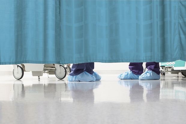 Feet of medical staff behind curtain
