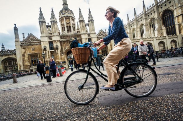 Cyclist outside University of Cambridge