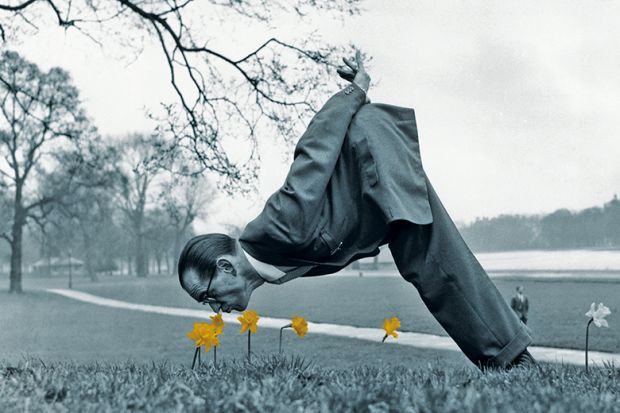 Man dressed in vintage suit sniffing daffodils