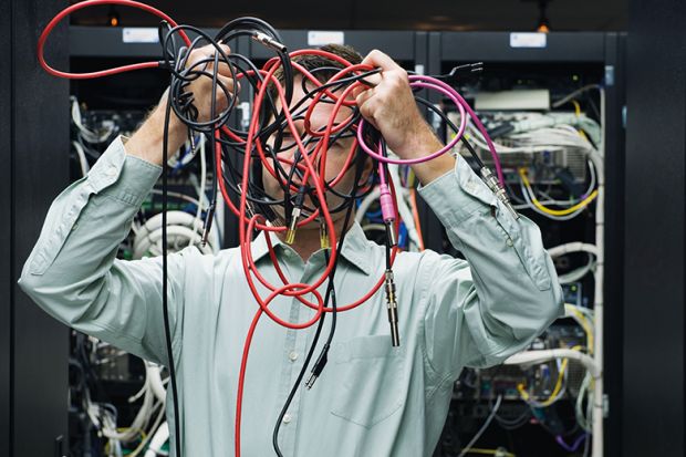 Man with tangled computer cables