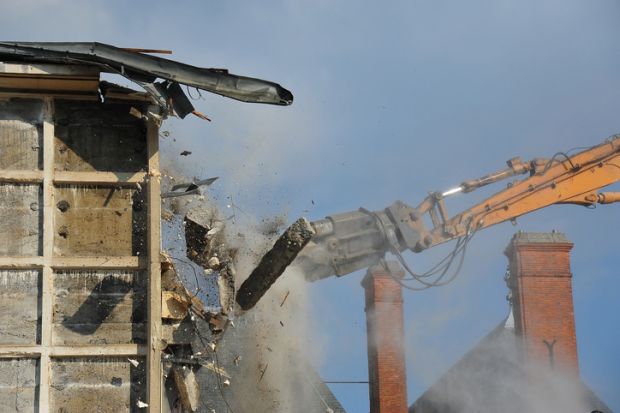 demolition of a dilapidated building using an industrial grinding pliers