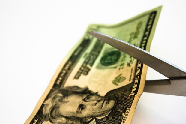 Scissors cut a $20 bill