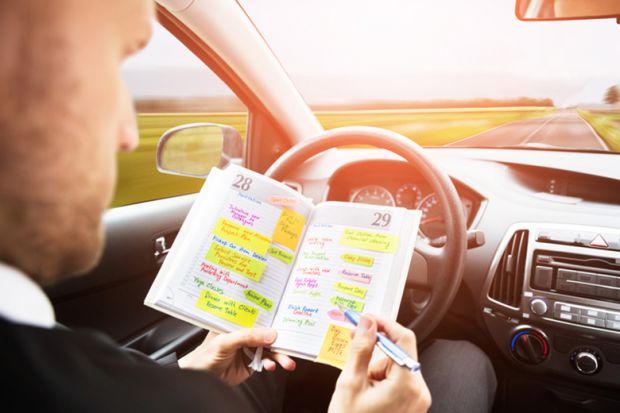 A man looking through his diary in a driverless car