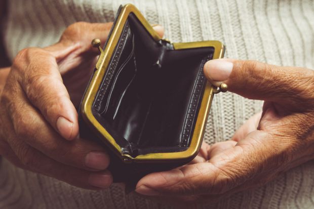 Elderly man holds in his hands an empty wallet
