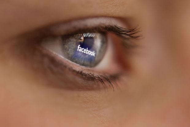 Reflection of Facebook logo on person's eye