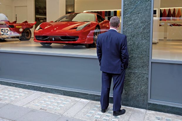 Man window shopping at Ferrari showroom