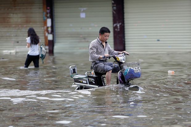 Man riding a bicycle in flood