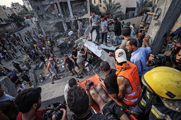 An injured man is pulled from rubble in Gaza