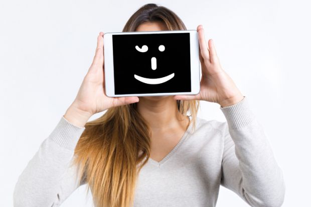 Girl holding a tablet computer with a smiley face on it