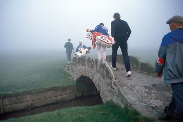 Golfers crossing a bridge in fog