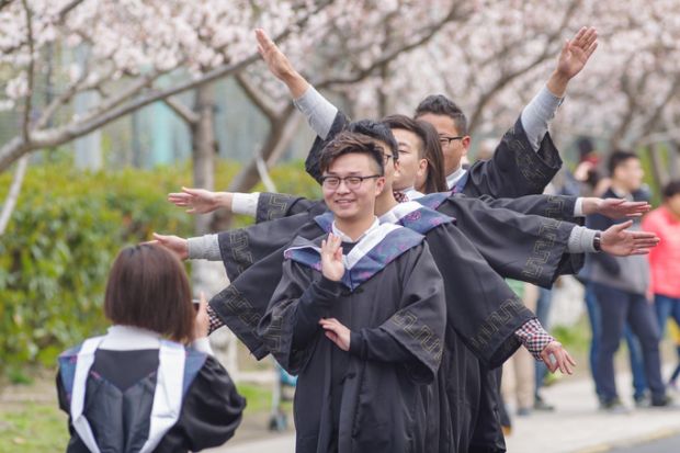 Graduating students taking photos in cherry festival in Tongji University.