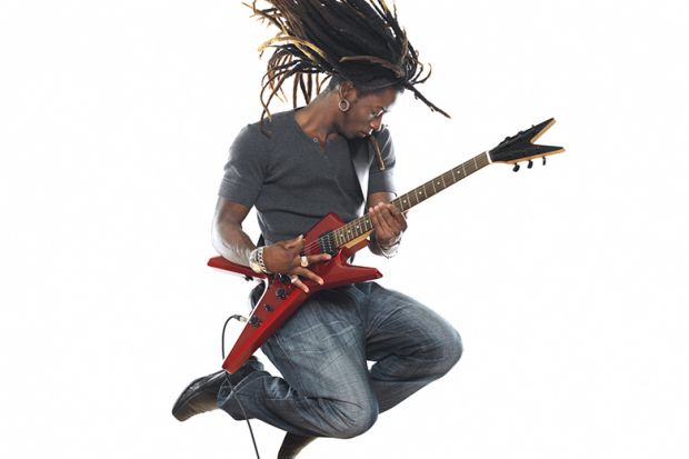 Musician leaps in air while playing electric guitar 