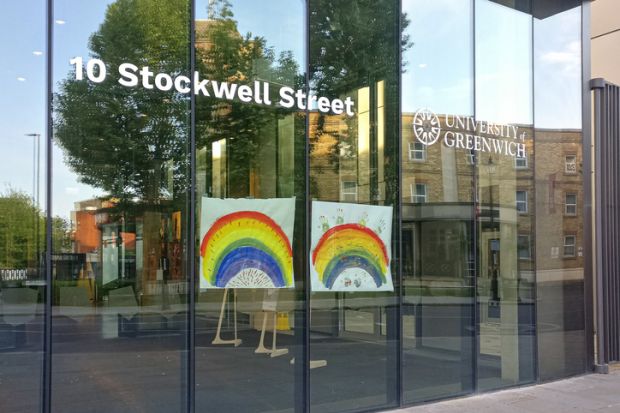 Hand drawn rainbow expressing thank to NHS and key workers displayed at glass window University of Greenwich during coronavirus outbreak