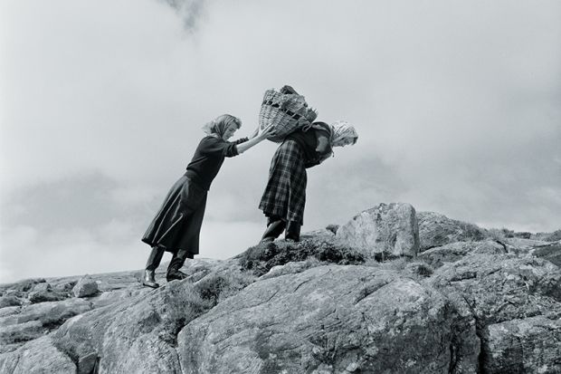 Two women carry heavy parcels
