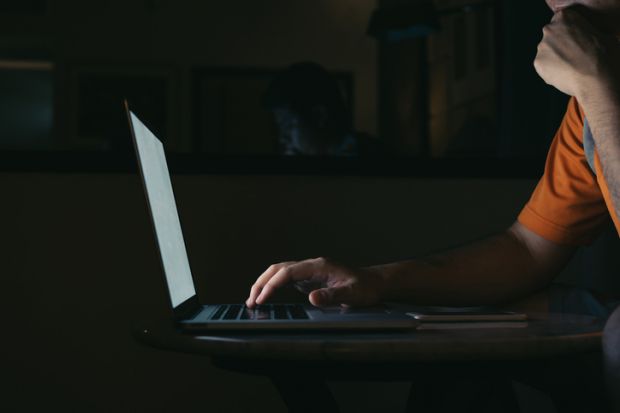 Man working on his computer laptop in night