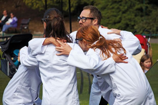 people wearing lab coats huddling together