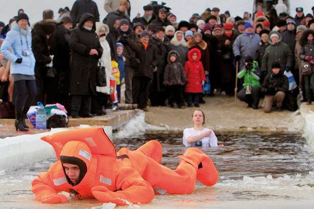 A rescue worker exits the icy waters of the Dnepr River in Kiev during an Orthodox Epiphany celebration