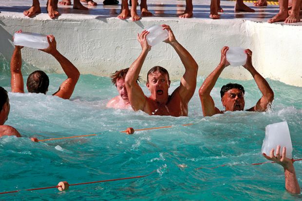 Swimmers holding ice cubes aloft