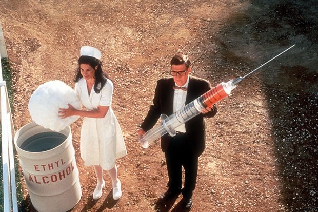 Nurse and man holding giant syringe