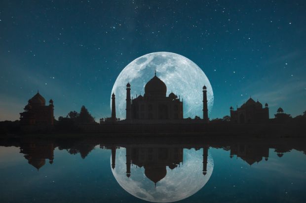 Taj Mahal silhouetted against the moon and reflected in water