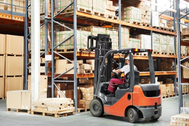 warehouse worker in uniform loading boxes by forklift to show lift and shift in transnational education