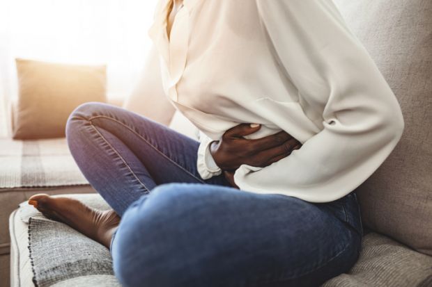 A woman clutches her stomach because of period pain