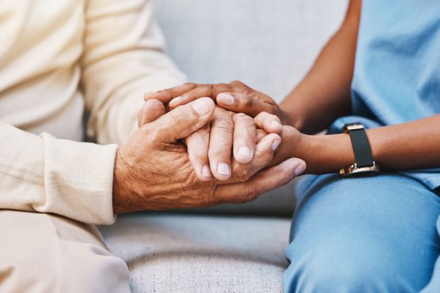 Close-up of carer holding hands with someone