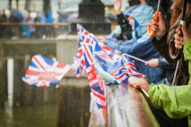 British people in heavy rain celebrating a parade