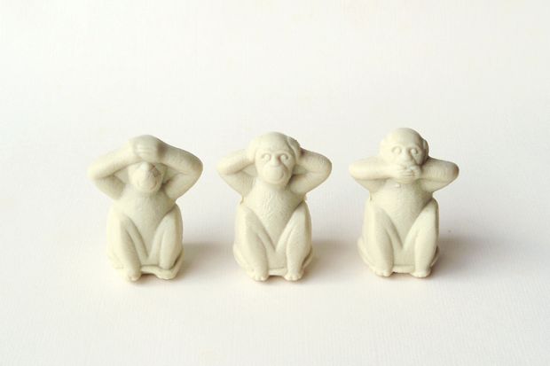 Three monkey statuettes in 'see no evil, hear no evil, speak no evil' poses