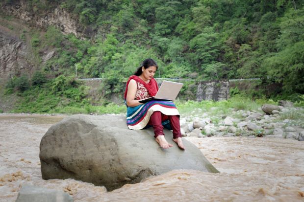 Indian woman in river with laptop