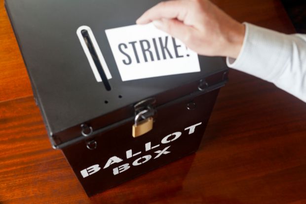 man placing strike ballot card into box