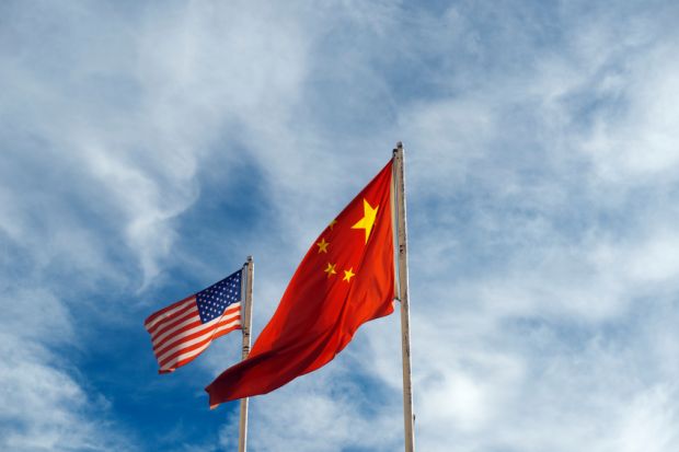US and China flags against blue sky