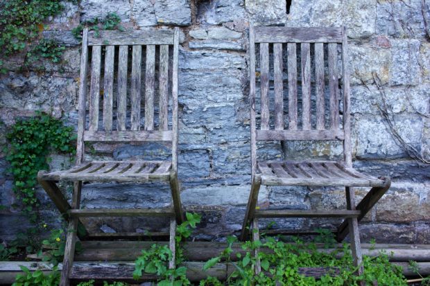 Pair of empty, aged wooden chairs