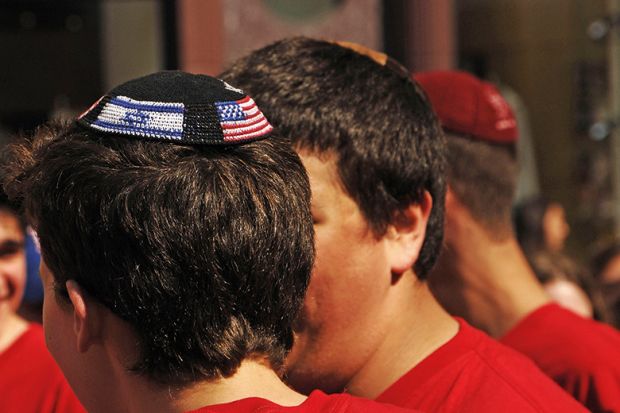 Young man wearing yarmulke with American and Israeli flags