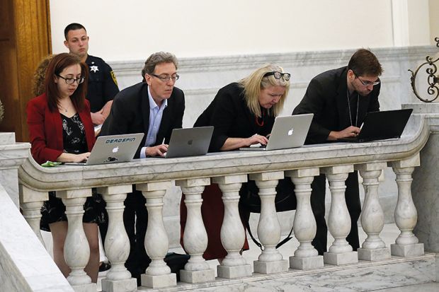 people work on laptops on balcony