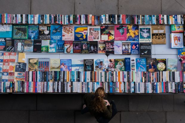 London, UK - October 22, 2016 A woman exploring used and second hand books and record bargains on London Thames Southbank.