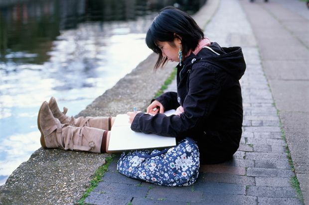 young woman sits by canal