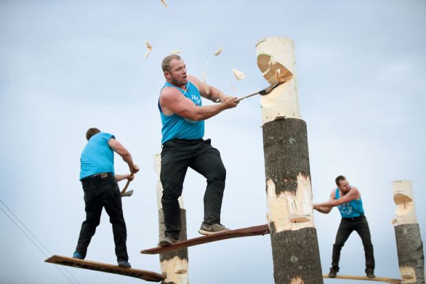 lumberjacks chop tree trunks in a lumberjack competition to illustrate University presidents are ‘driven by fear’ with him having to make cuts