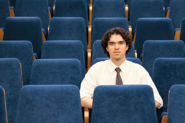 Male student sitting alone in lecture hall