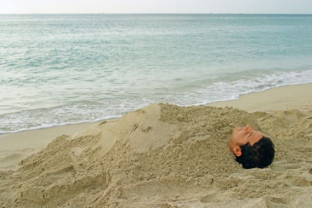 Man buried in sand on beach