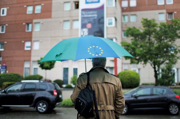 Man carrying a European Union (EU)-branded umbrella