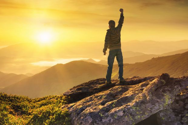 Man celebrating climb to mountain peak